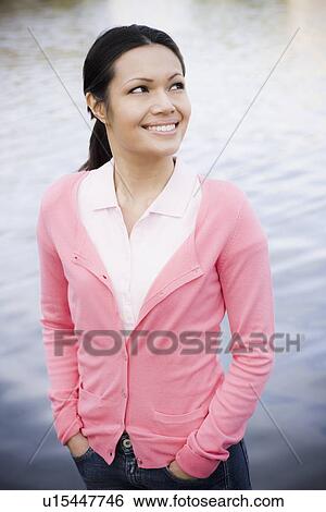 Woman smiling by waterfront View Large Photo Image Stock Photograph - Woman smiling by waterfront. Fotosearch