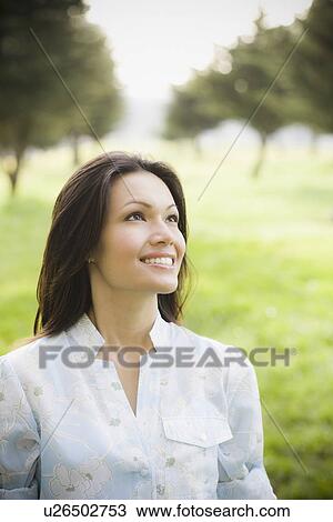 Stock Image - Woman smiling in park. Fotosearch