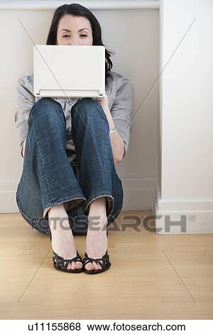 Stock Photo - Woman using laptop on floor. Fotosearch
