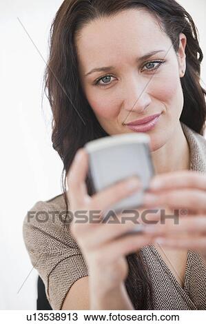 Stock Image - "Woman using palmtop, smiling". Fotosearch