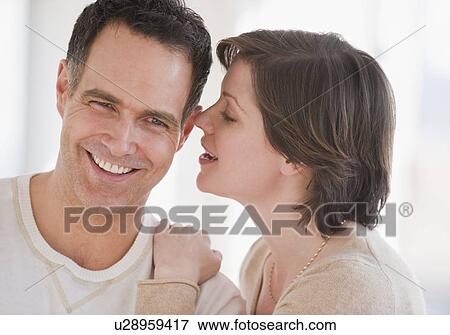 Woman whispering to man's ear View Large Photo Image Stock Photo - Woman whispering to man's ear. Fotosearch
