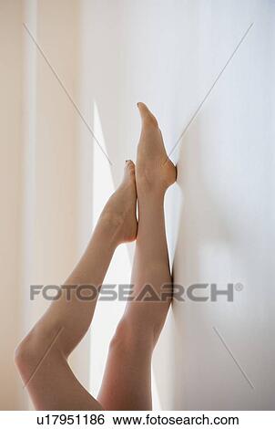 Woman with feet against wall View Large Photo Image Stock Photograph - Woman with feet against wall. Fotosearch
