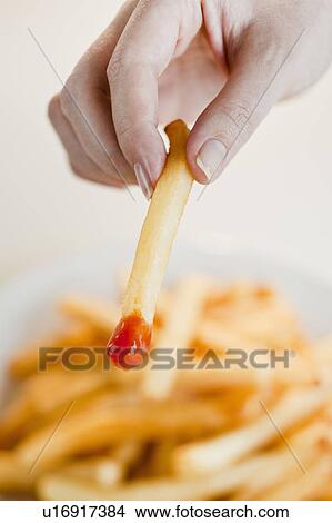 "Woman with french fries, close-up of hand" View Large Photo Image Picture - "Woman with french fries, close-up of hand". Fotosearch