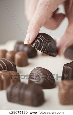 Stock Image - Woman's hand holding chocolate. Fotosearch