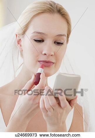 Young bride applying lipstick View Large Photo Image Stock Image - Young bride applying lipstick. Fotosearch