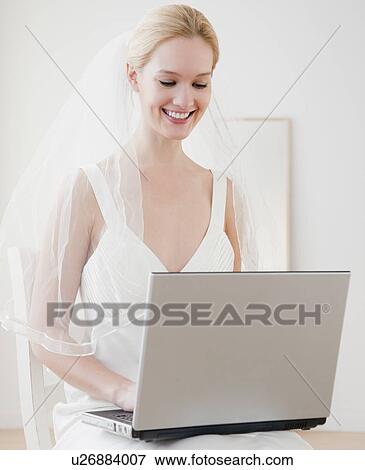 Stock Photo - Young bride surfing on internet. Fotosearch