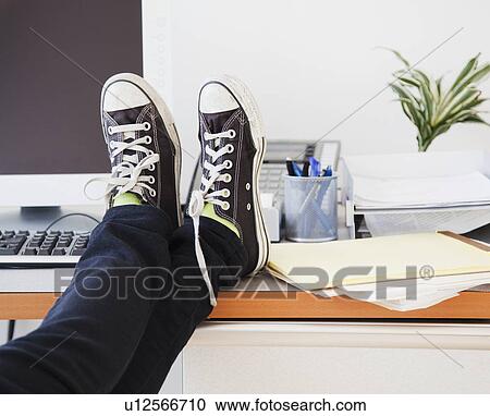 Young office worker in casual clothes relaxing in office with legs on desk View Large Photo Image Stock Image - Young office worker in casual clothes relaxing in office with legs on desk. Fotosearch