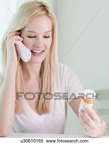 "Young woman on phone, holding pill bottle" View Large Photo Image Stock Photography - "Young woman on phone, holding pill bottle". Fotosearch
