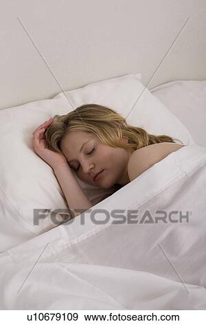 Stock Photo - Young woman sleeping in bed. Fotosearch