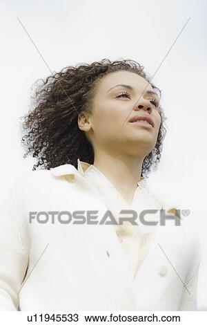 Stock Image - "Young woman smiling, outdoors". Fotosearch