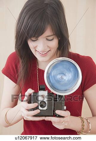 "Young woman using camera, studio shot" View Large Photo Image Stock Photo - "Young woman using camera, studio shot". Fotosearch