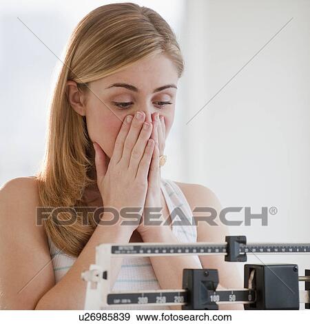 Young woman using measuring scales View Large Photo Image Stock Photo - Young woman using measuring scales. Fotosearch
