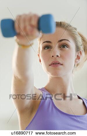 Stock Photo - Young woman weight lifting. Fotosearch