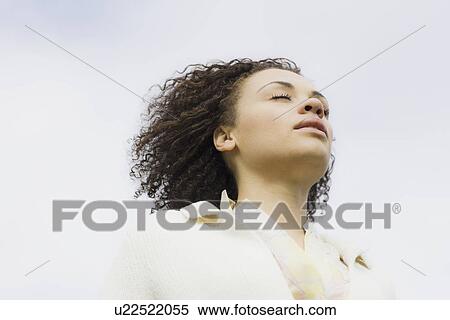 Stock Photography - "Young woman with eyes closed, outdoors". Fotosearch