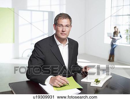 Stock Image - Architect at work in loft office. Fotosearch