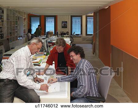 Stock Image - Architects discussing project. Fotosearch