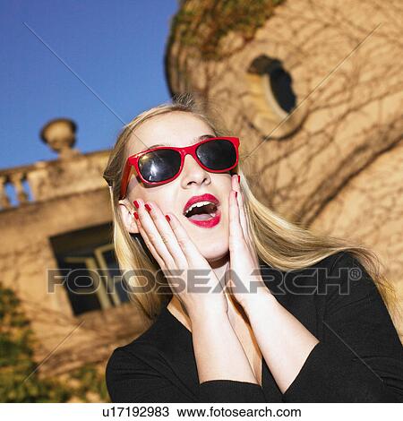 Stock Image - Blond woman with red glasses. Fotosearch