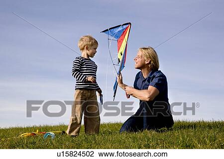 Stock Image - Boy and father put together a Kite. Fotosearch