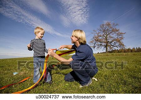 Stock Photo - Boy and father put together a Kite. Fotosearch