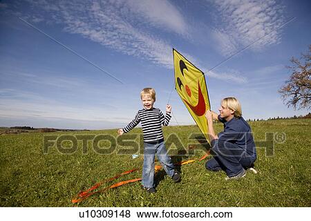 Boy and father start a Kite View Large Photo Image Stock Photo - Boy and father start a Kite. Fotosearch