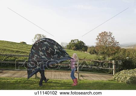 Stock Image - Boy and girl carrying tent. Fotosearch