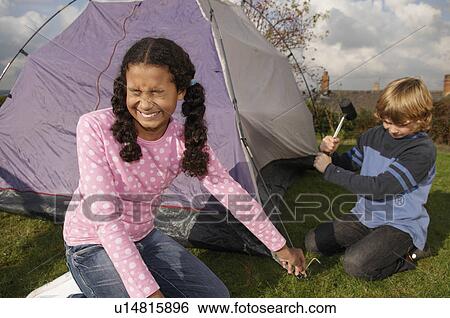 Stock Photograph - Boy and Girl erecting tent. Fotosearch