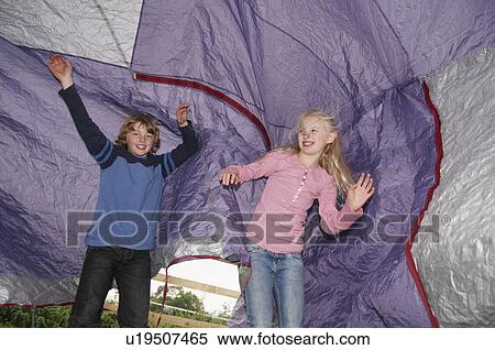 Stock Photography - Boy and girl playing under tent. Fotosearch