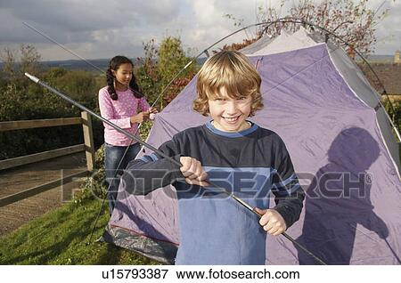 Stock Photo - Boy and girl putting up tent. Fotosearch