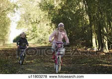 Boy and girl riding bikes in countryside View Large Photo Image Stock Photo - Boy and girl riding bikes in countryside. Fotosearch