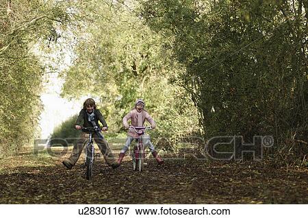 Boy and girl riding bikes in countryside View Large Photo Image Stock Photo - Boy and girl riding bikes in countryside. Fotosearch