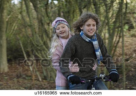Stock Photography - Boy and girl sharing bike in countryside. Fotosearch