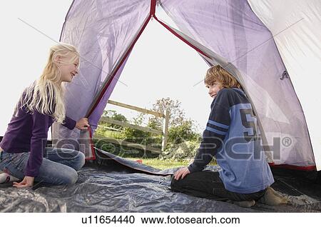 Stock Image - Boy and Girl sitting in tent. Fotosearch