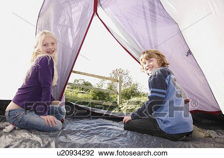 Stock Image - Boy and Girl sitting in tent. Fotosearch