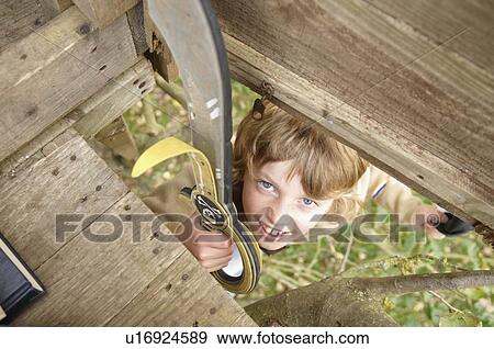 Stock Photo - Boy climbing to treehouse. Fotosearch