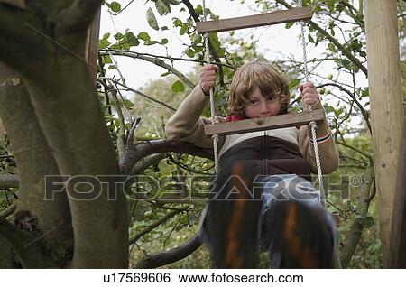 Stock Photograph - Boy climbing to treehouse. Fotosearch