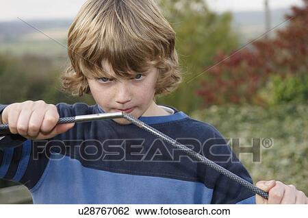 Stock Image - Boy erecting tent poles. Fotosearch