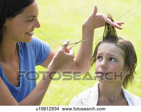 Picture - Boy gets his hair cut by woman. Fotosearch