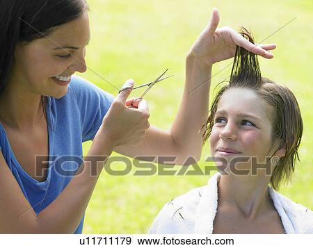 Stock Photo - Boy gets his hair cut by woman. Fotosearch