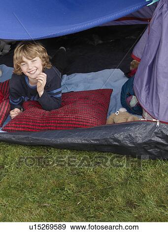 Stock Photo - Boy looking out of tent. Fotosearch