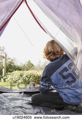 Stock Photography - Boy looking out of tent. Fotosearch