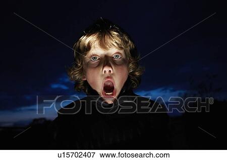 Stock Photo - Boy making faces with flashlight. Fotosearch