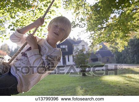 Stock Photograph - Boy on a swing. Fotosearch