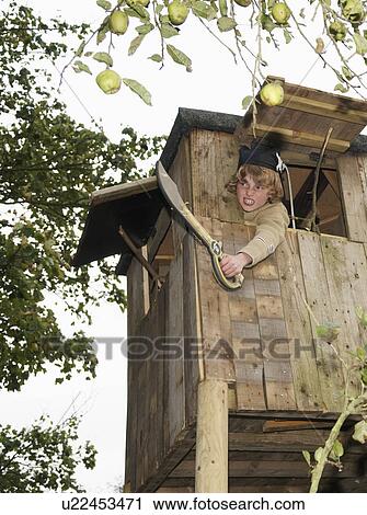 Stock Image - Boy playing in treehouse. Fotosearch