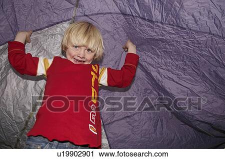 Stock Image - Boy playing under tent. Fotosearch