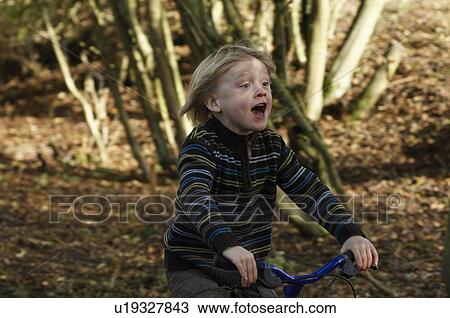 Stock Image - Boy riding bike in countryside. Fotosearch