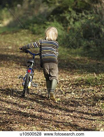 Stock Photo - Boy riding bike in countryside. Fotosearch
