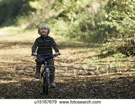 Stock Photo - Boy riding bike in countryside. Fotosearch