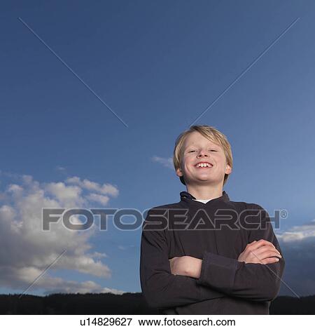 Stock Photo - "Boy standing with arms crossed, smiling". Fotosearch