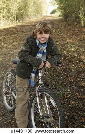 Boy with bike on country lane View Large Photo Image Stock Image - Boy with bike on country lane. Fotosearch