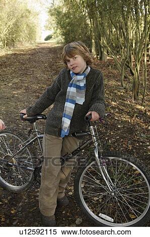 Stock Photography - Boy with bike on country lane. Fotosearch
